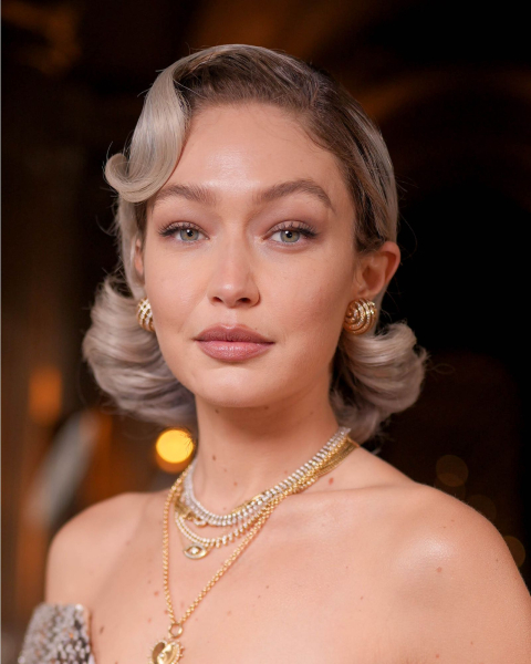 Wavy bell bob on cooltoned blonde hair styled in old Hollywood glamour swirls on Gigi Hadid.