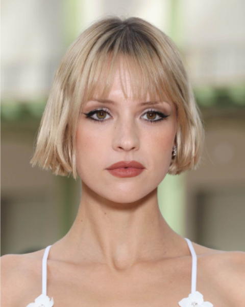 Short blonde French bob with fringe bangs on Angele Van Laeken.