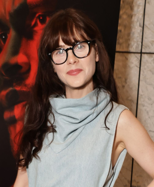Zooey Deschanel wearing glasses and funnel neck sleeveless denim dress