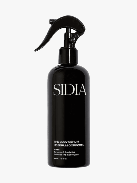 Sidia The Body Serum in branded black spray bottle with white accents on a light gray background